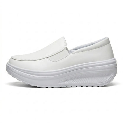 Weißer Slipper mit Keilsohle in der Seitenansicht, Gummizug und profilierte Sohle erkennbar 10