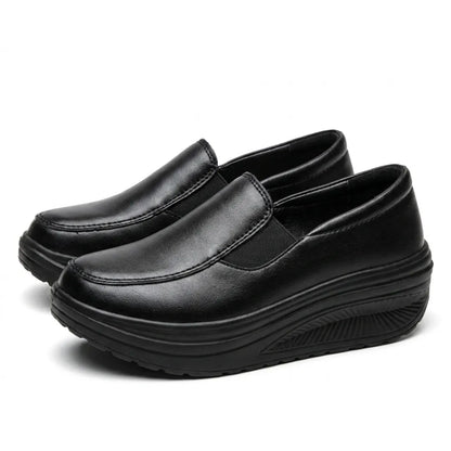 Paar schwarze Slipper mit dicker Keilsohle in schräger Vorderansicht 7