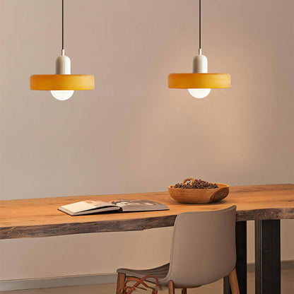 Moderne bunte Glas-Pendelleuchte, orange, über Holztisch, skandinavisches Design.