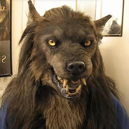 Nahaufnahme der getragenen Werwolfmaske von vorn mit geöffnetem Maul, gelben Zähnen, spitzen Ohren und zotteligem braunem Fell. 3