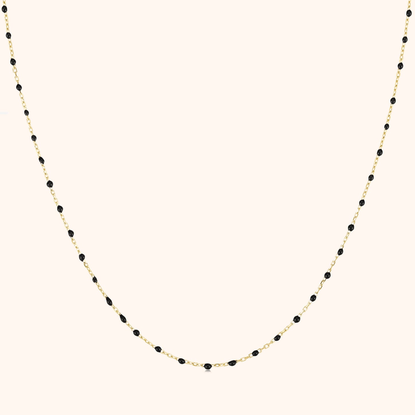 Goldene Halskette mit schwarzen Perlen, elegantes Schmuckdesign, Damenaccessoire.