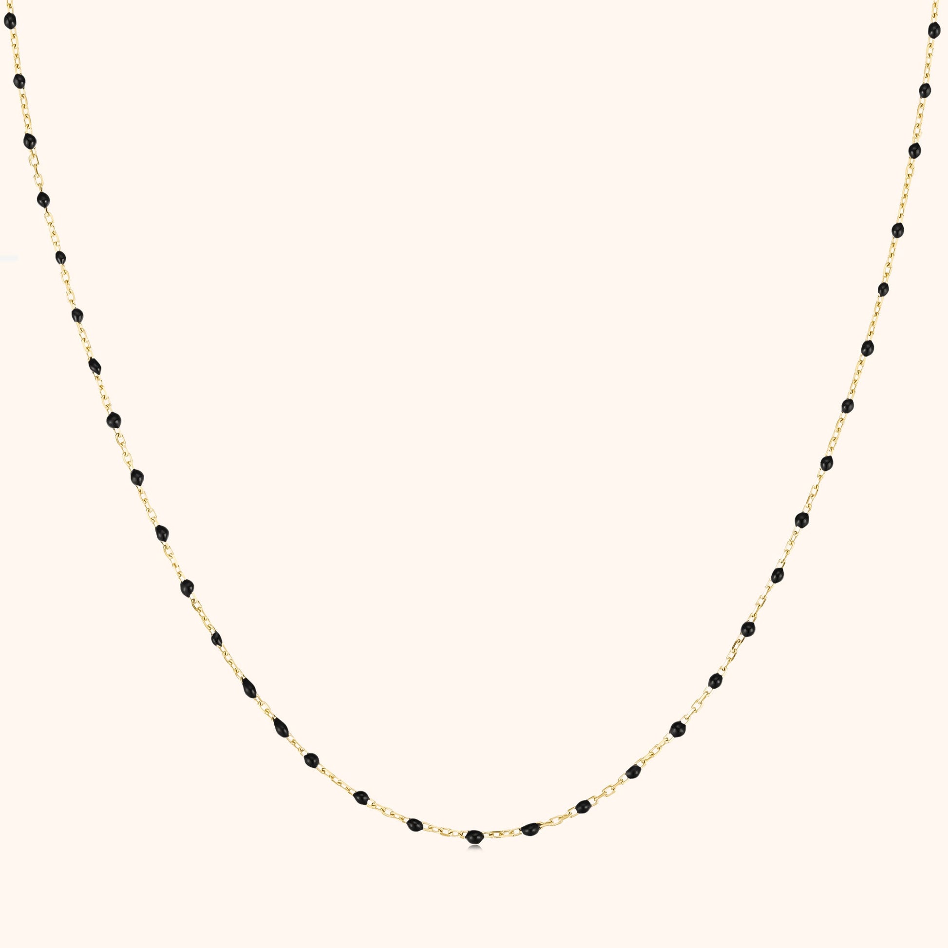 Goldene Halskette mit schwarzen Perlen, elegantes Schmuckdesign, Damenaccessoire.