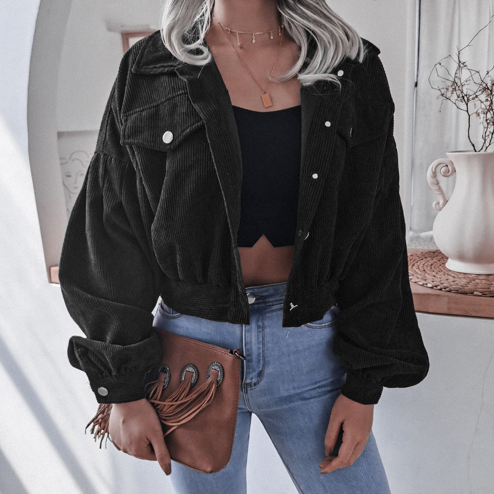Frau in schwarzer Cordjacke, blauer Jeans, braunem Lederbeutel, modisch, lässig.