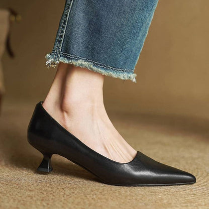 Seitenansicht eines schwarzen Pumps am Fuß, mit Blick auf Trichterabsatz und spitze Zehenpartie, dazu Jeans 14