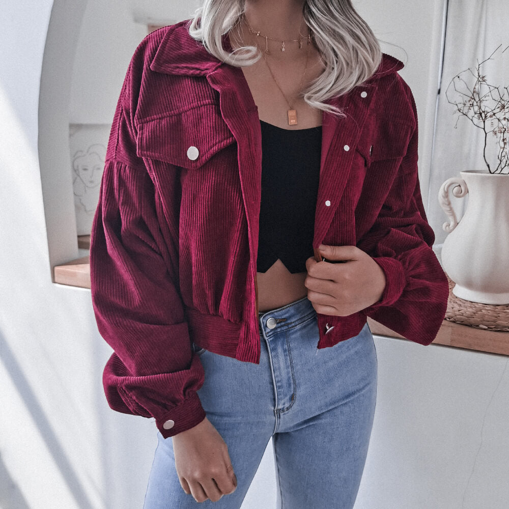Frau in roter Cordjacke, schwarze Bluse, blaue Jeans, modisch, lässig, Herbstmode.
