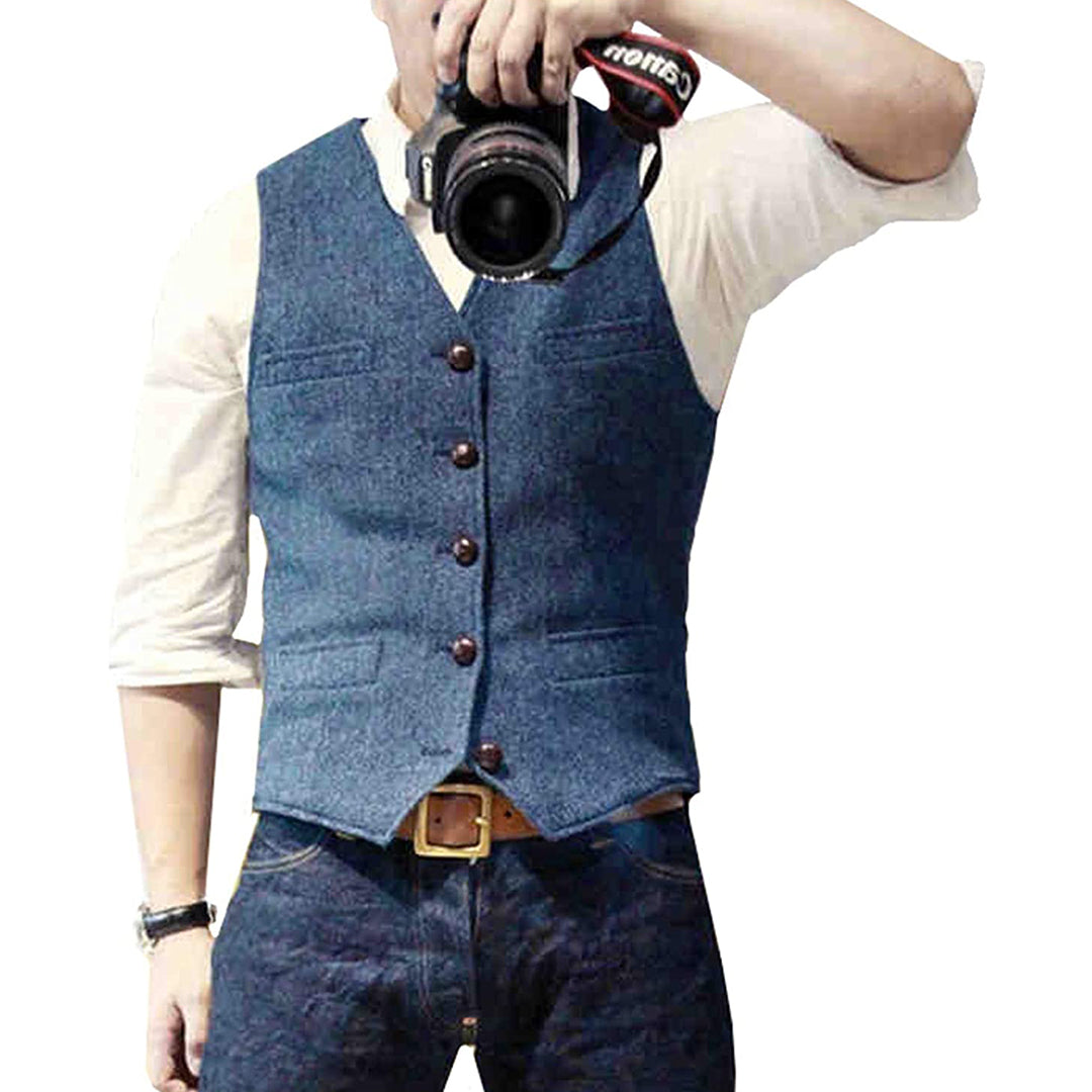 Mann in blauem Tweed-Weste, weißem Hemd, Jeans, hält Kamera.