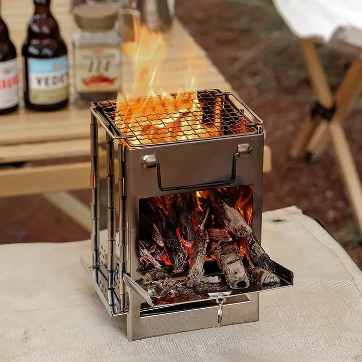 Kompakte Edelstahl-Holzofen für Camping, tragbar, mit Feuer, ideal für Outdoor-Abenteuer.