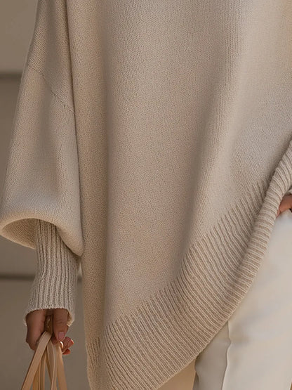 Detailansicht des schräg verlaufenden gerippten Saums und des Fledermausärmels mit Rippbündchen am beigen Pullover. 3