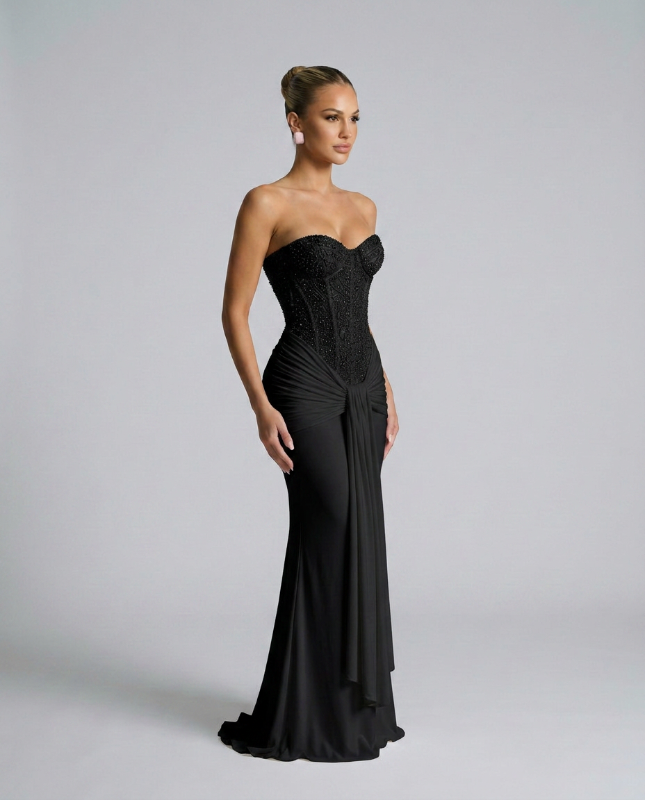 Schwarzes Maxikleid mit Korsagenoberteil und fließender Draperie, seitlich von vorn am Model gezeigt 2