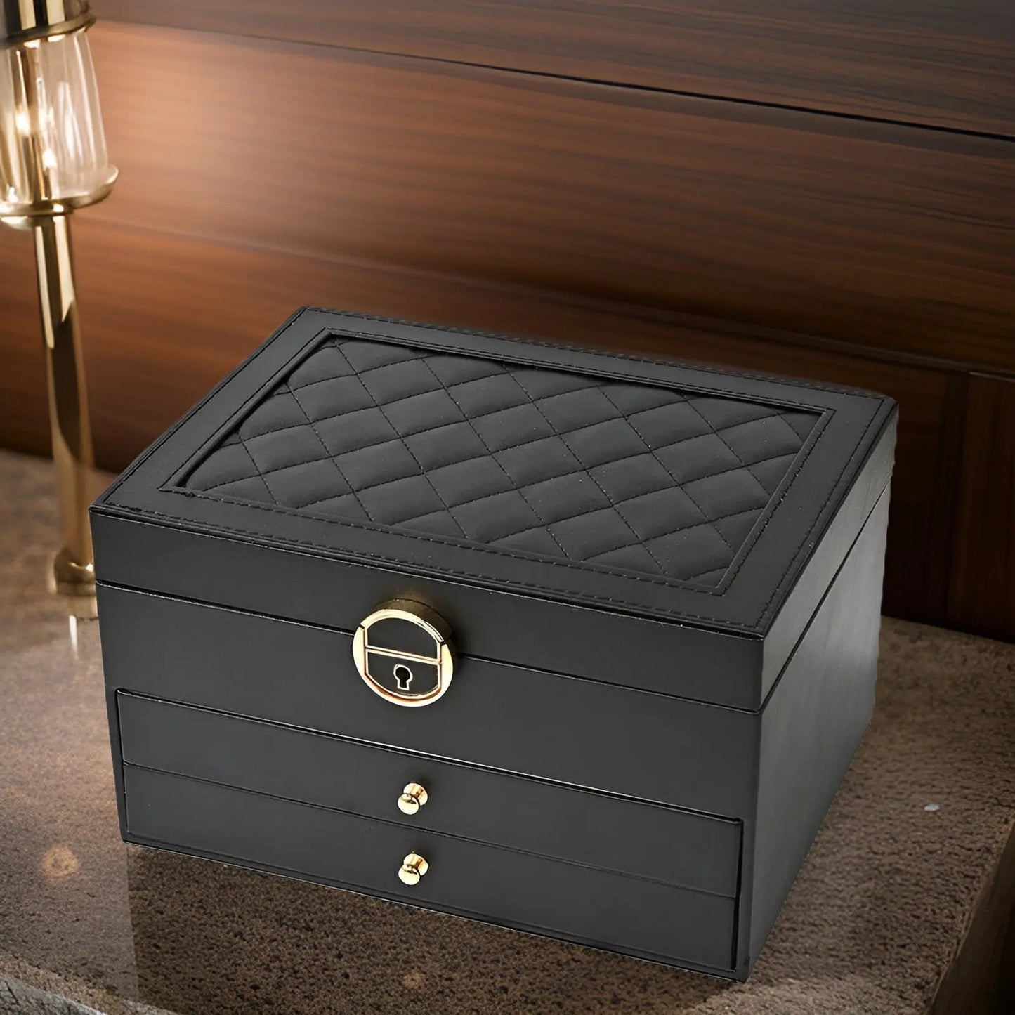 Schwarze Schmuckschatulle aus Leder mit Rautenmuster, zwei Schubladen, goldene Beschläge.