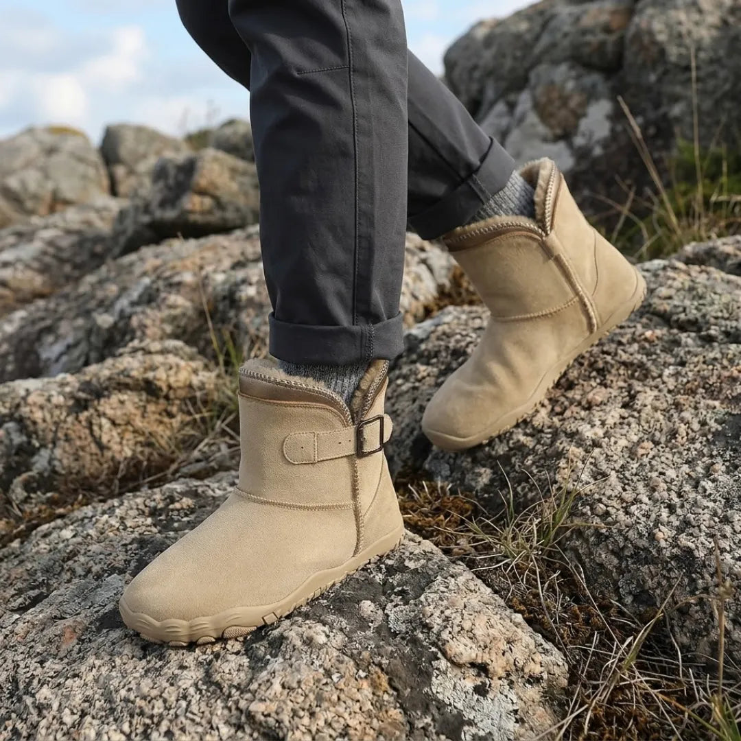 Beige Stiefel an den Füßen eines Trägers beim Gehen über Felsen, mit grauen Socken 2