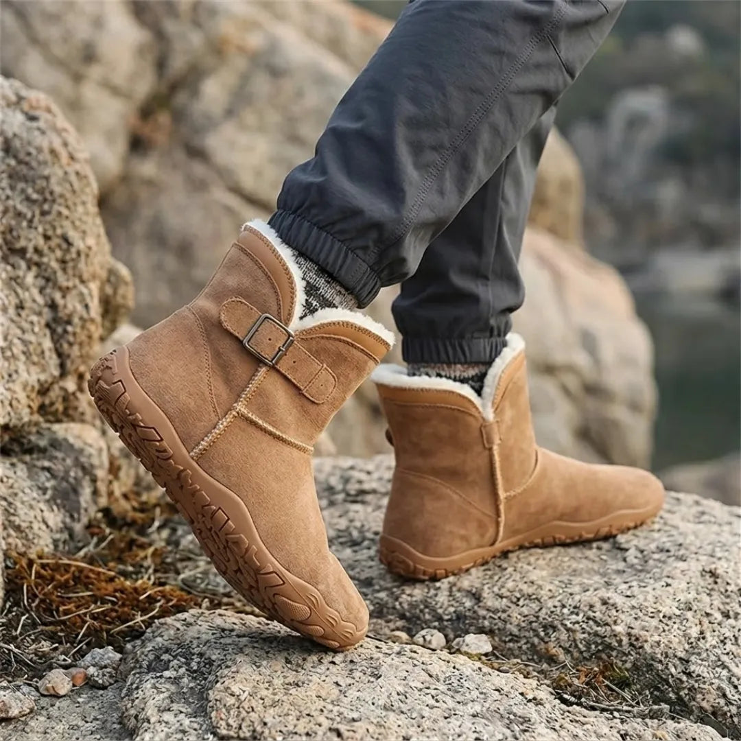Braune Stiefel mit hellem Fellfutter, getragen beim Gehen auf Felsen, mit grauer Jogginghose 20