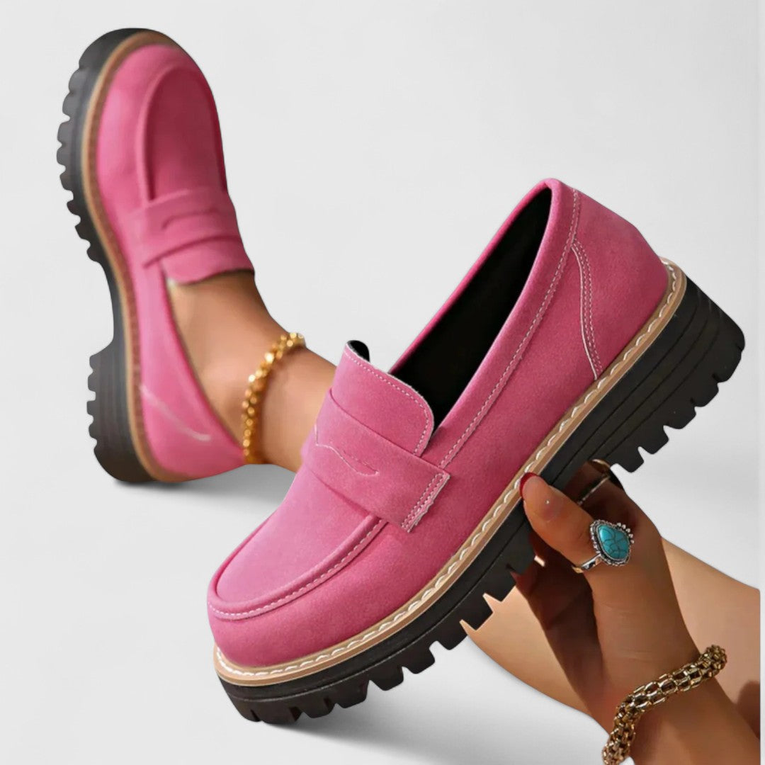 Pinkfarbene Loafer, ein Schuh in der Hand gehalten, der andere am Fuß mit Fußkettchen 3