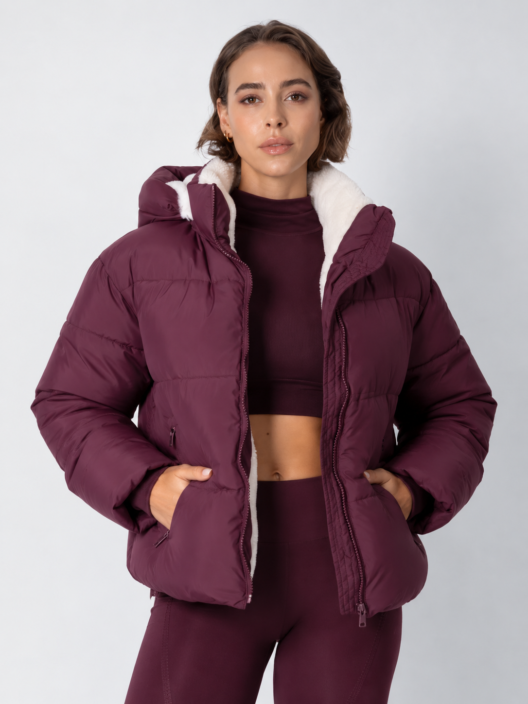 Beerenfarbene Steppjacke offen über passendem Crop-Top, mit cremefarbenem Fleecefutter und Kapuze 16