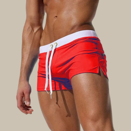 Rote Herren-Badeshorts mit weißem Bund und Kordelzug, sportlich, eng anliegend.
