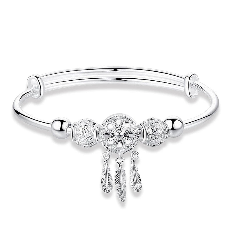 Silbernes Damenarmband mit Kreuzanhänger und Federn, elegantes Schmuckdesign.