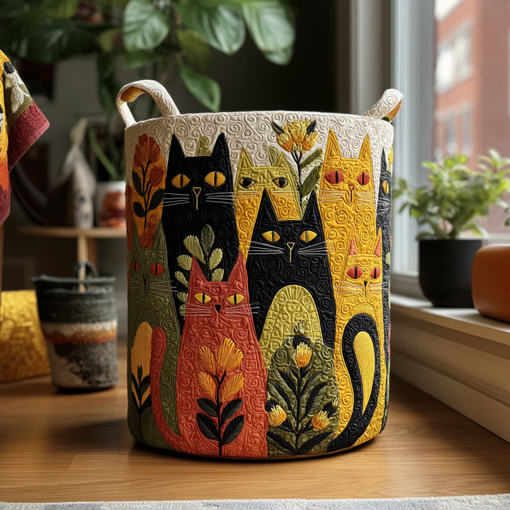 Gesteppter Korb mit buntem Katzenmotiv in Schwarz, Gelb, Rot und Grün steht auf einem Holzboden vor einem Fenster mit Zimmerpflanzen. 1