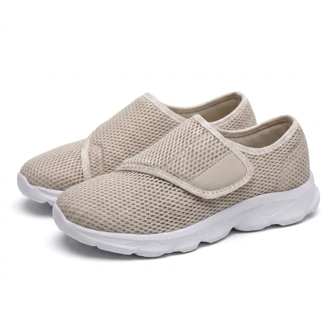 Paar beige Netzschuhe mit breitem Klettverschluss und weißer Sohle, schräg von vorn auf weißem Hintergrund fotografiert. 34