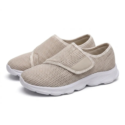 Paar beige Netzschuhe mit breitem Klettverschluss und weißer Sohle, schräg von vorn auf weißem Hintergrund fotografiert. 34