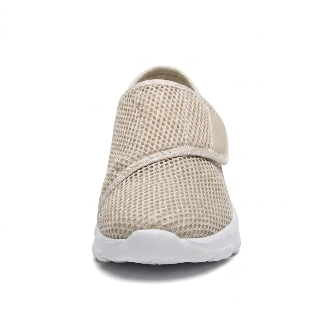 Frontansicht eines beigen Netzschuhs mit Klettband über dem Rist und weißer Sohle, die die breite Form der Schuhspitze zeigt. 35