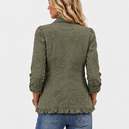 Rückansicht am Model: Großflächige florale Stickerei auf dem Rücken der olivgrünen Jacke, mit Rüschensaum und Ärmelaufschlägen. 5