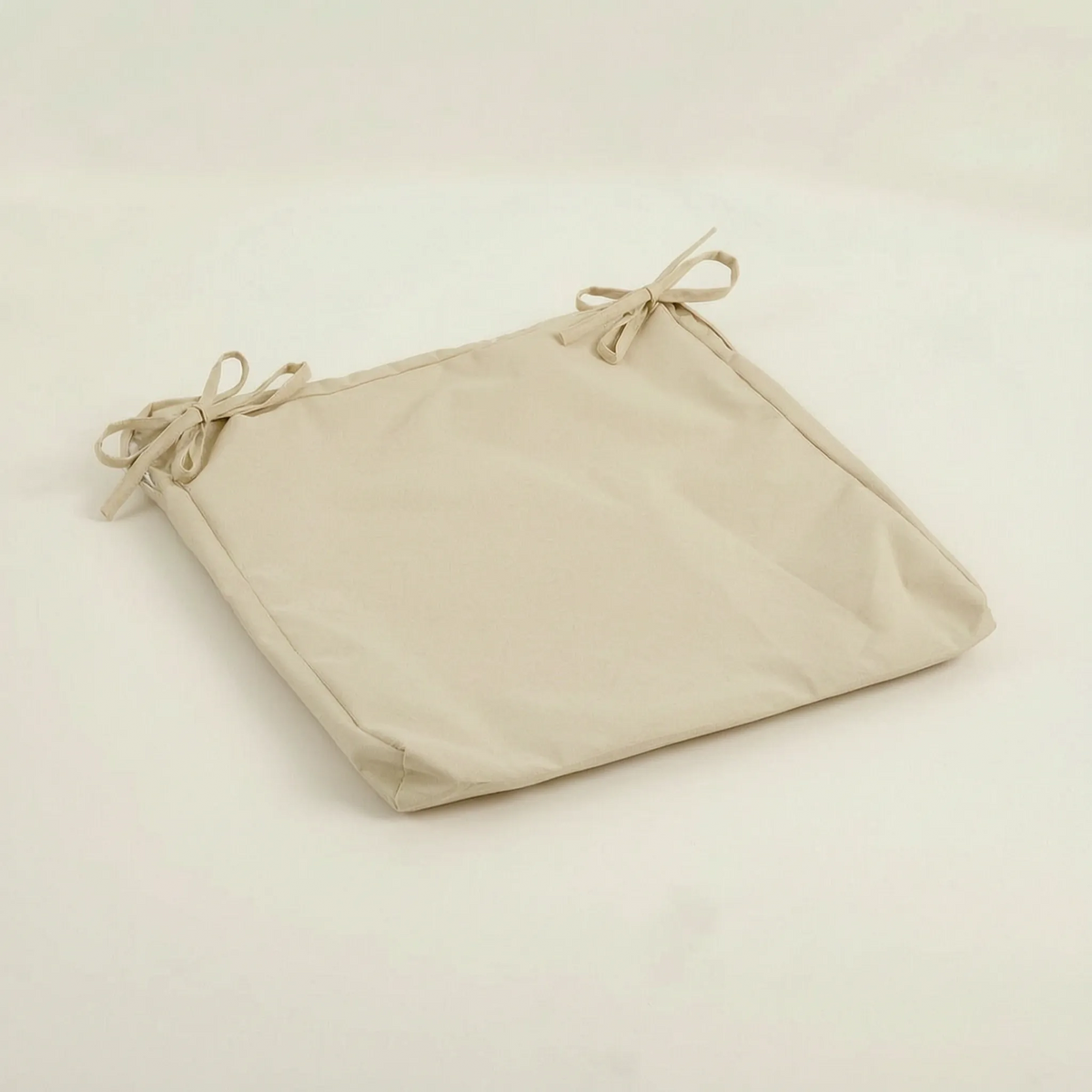 Sitzkissen in Creme mit zwei Schleifenbändern, flach auf hellem Untergrund liegend 13