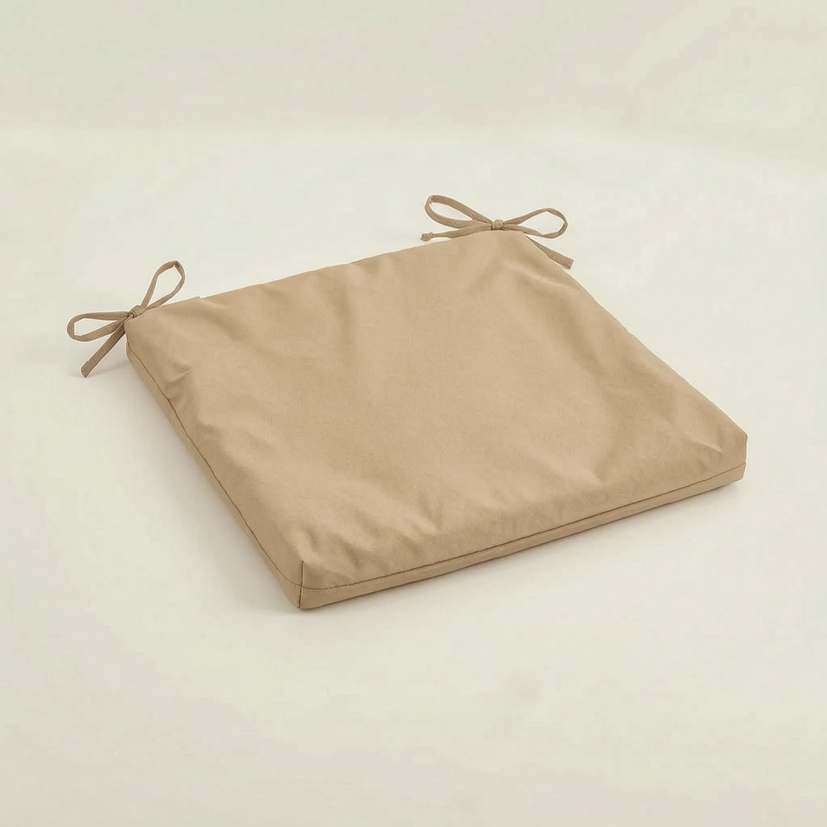 Sitzkissen in Sandbeige mit zwei Schleifenbändern an der Rückseite, auf hellem Untergrund 5
