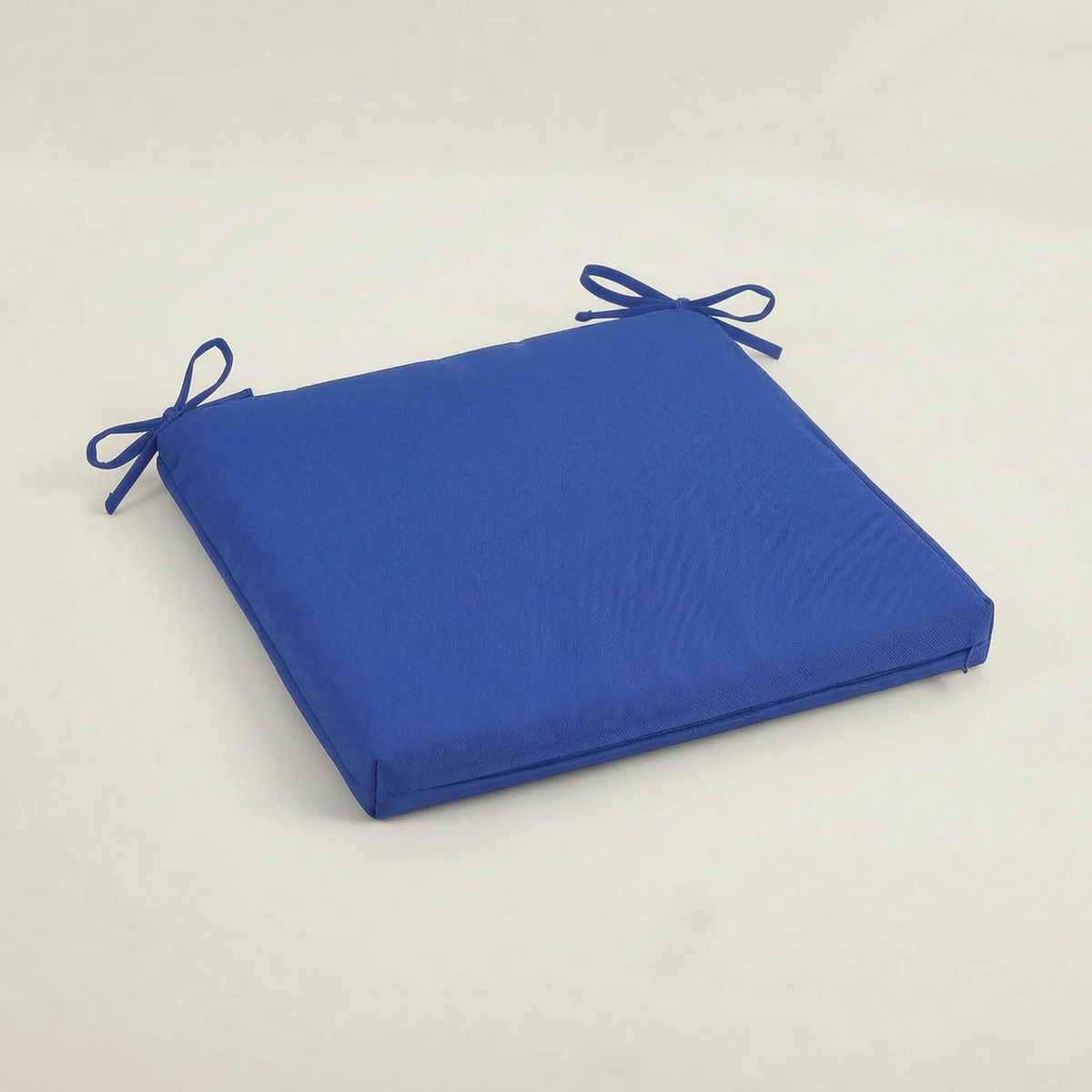 Sitzkissen in kräftigem Blau mit zwei gebundenen Bändern, flach auf hellem Hintergrund 6