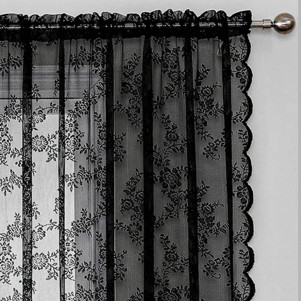 Detailansicht der oberen Ecke eines schwarzen Schals mit Stangendurchzug, Blumenmuster und gewellter Seitenkante an einer Metallstange mit Knauf. 4