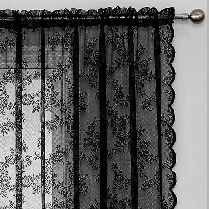 Detailansicht der oberen Ecke eines schwarzen Schals mit Stangendurchzug, Blumenmuster und gewellter Seitenkante an einer Metallstange mit Knauf. 4