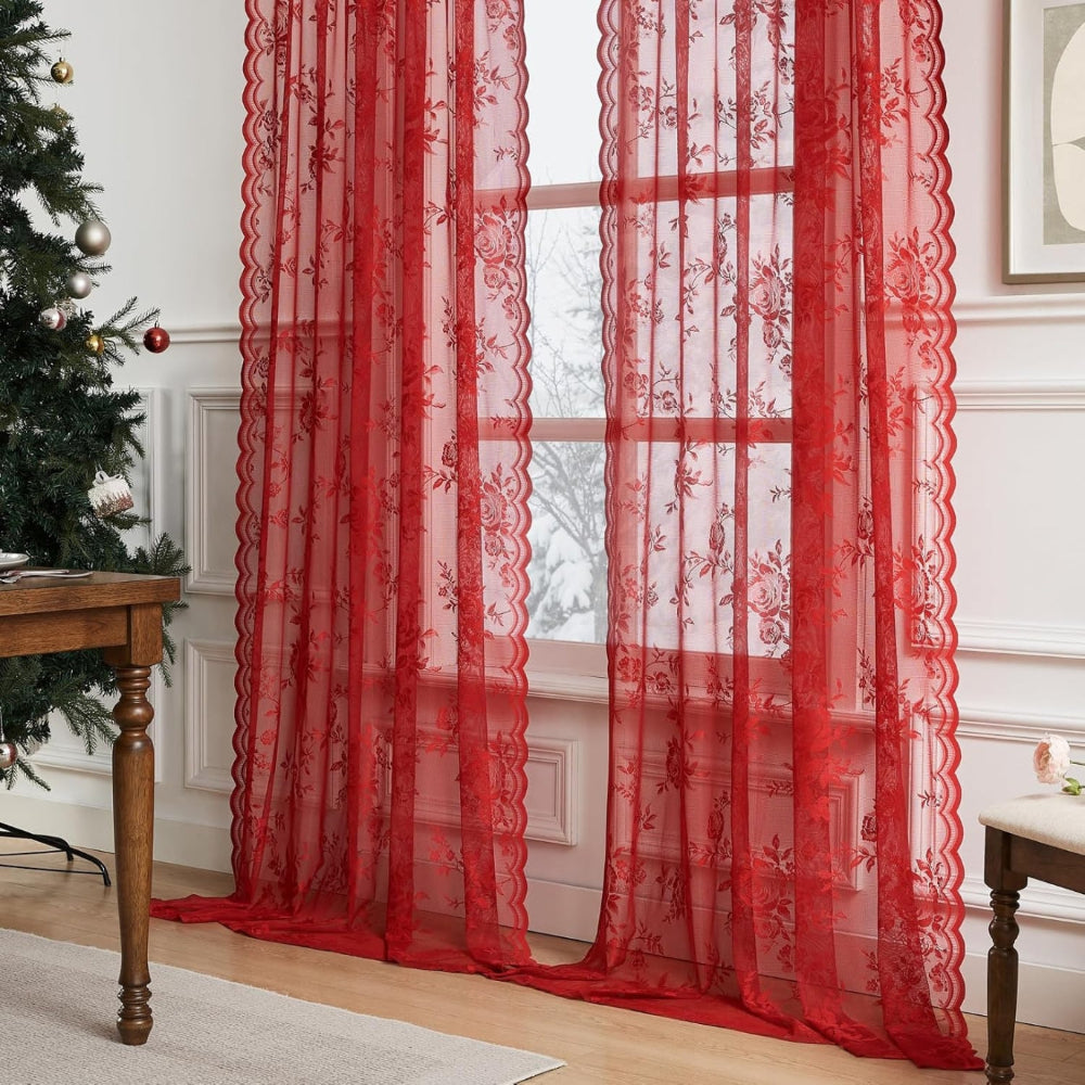 Zwei rote Schals mit Rosenmuster und Wellenkante vor einem Fenster mit Schneeblick, daneben Tannenbaum und Holztisch in weihnachtlicher Umgebung. 7