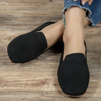 Schwarze Damen-Loafers aus Stoff, bequem, lässig, ideal für den Alltag, auf Holzboden.