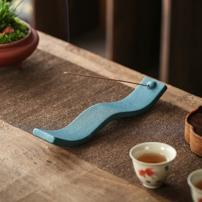 Blauer Keramik-Räucherstäbchenhalter auf Holztisch, dekorativ, modern, asiatisches Design.