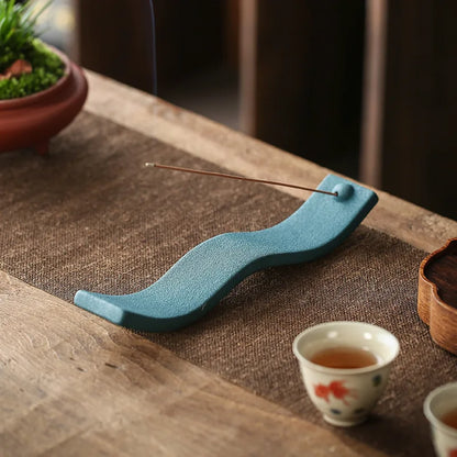 Blauer Keramik-Räucherstäbchenhalter auf Holztisch, dekorativ, modern, asiatisches Design.