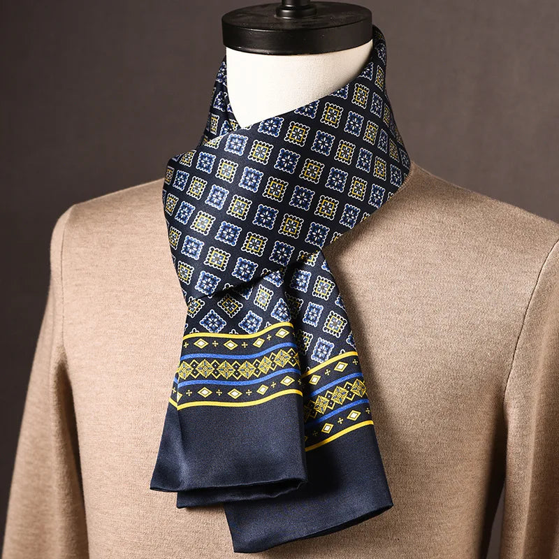 Dunkelblauer Seidenschal mit quadratischem Blütenmuster in Blau und Gelb sowie gelb-blauer Bordüre, an einer Büste mit beigem Pullover drapiert. 22