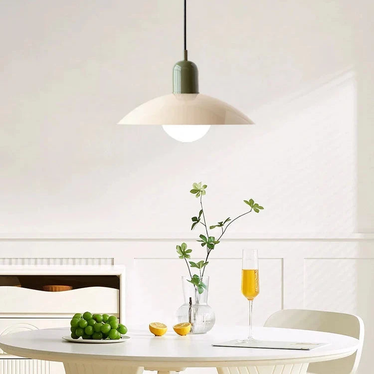 Pendelleuchte mit grüner Fassung und cremefarbenem Schirm über einem weißen Tisch mit Trauben und Zitrone 6