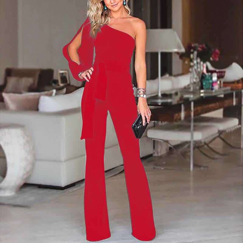 Frau in rotem, schulterfreiem Jumpsuit, elegantes Abendoutfit, moderne Mode, Wohnzimmer.