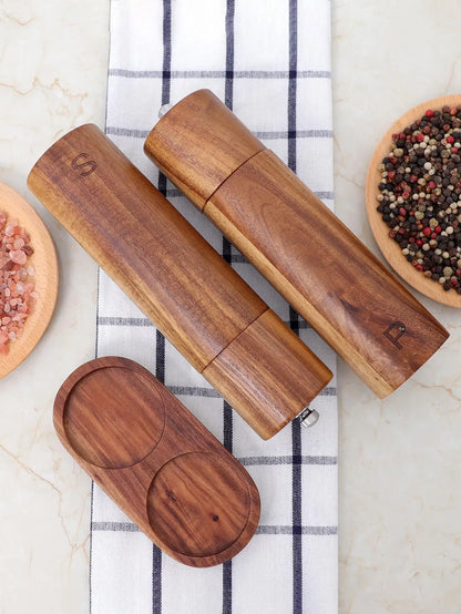 Salz- und Pfeffermühlen aus Holz, graviert, auf kariertem Tuch, mit rosa und buntem Pfeffer.