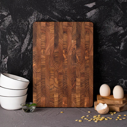 Holz-Schneidebrett auf dunklem Hintergrund, umgeben von weißen Schalen und Eiern.
