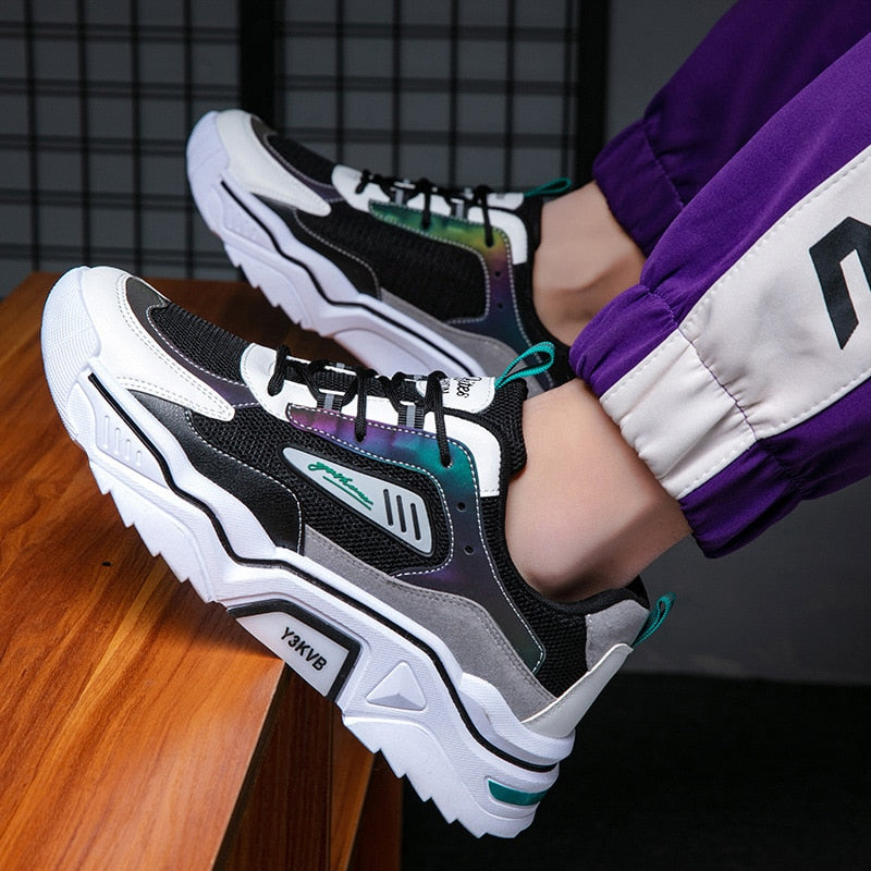 Schwarz-weiße Sneaker mit dicker Sohle, sportlich, modisch, Unisex, auf Holzboden.