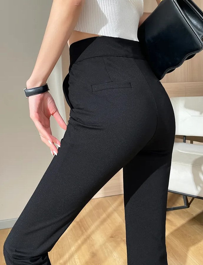 Frau in schwarzer Hose und weißem Top, hält schwarze Tasche, modisch, elegant, modern.