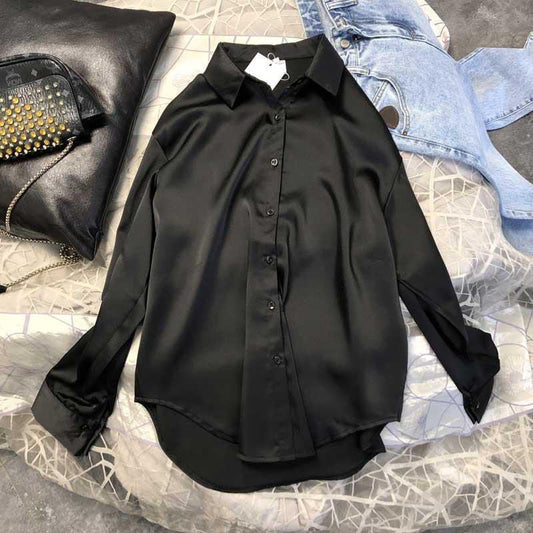 Schwarze Seidenbluse, langärmelig, elegant, Damenmode, auf Bett mit Jeans und Tasche.