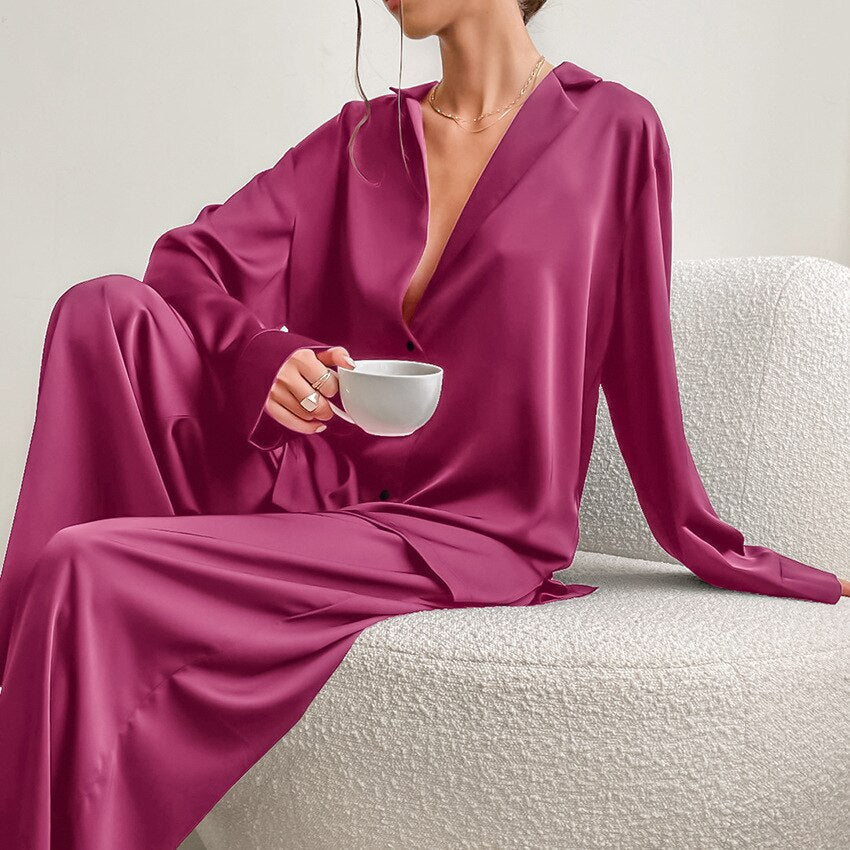 Frau in lila Satin-Pyjama mit Kaffeetasse, elegantes Lounge-Outfit, gemütliche Mode.