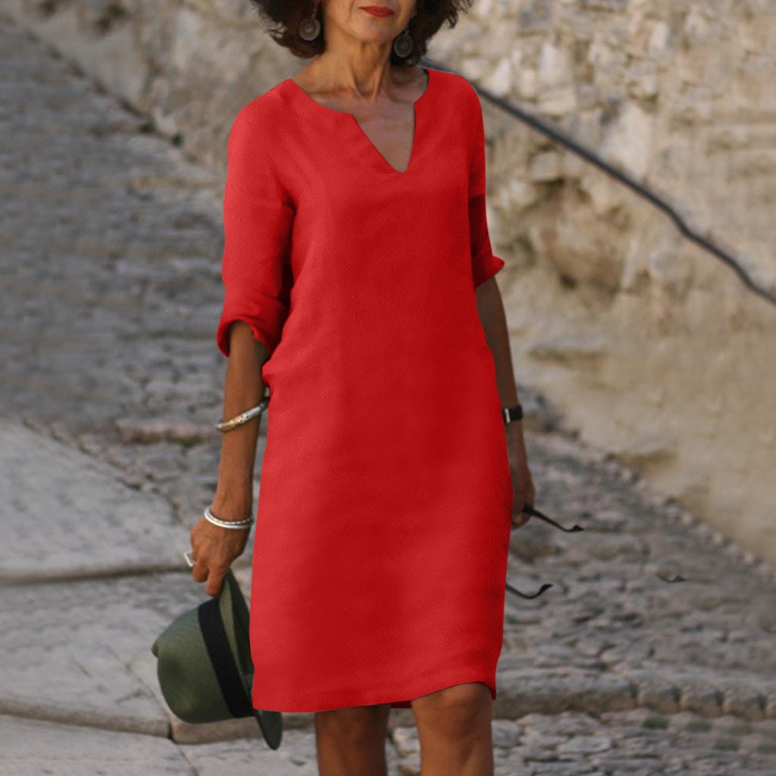Frau in rotem Sommerkleid auf Kopfsteinpflaster, modisch, elegant, Freizeitkleidung.