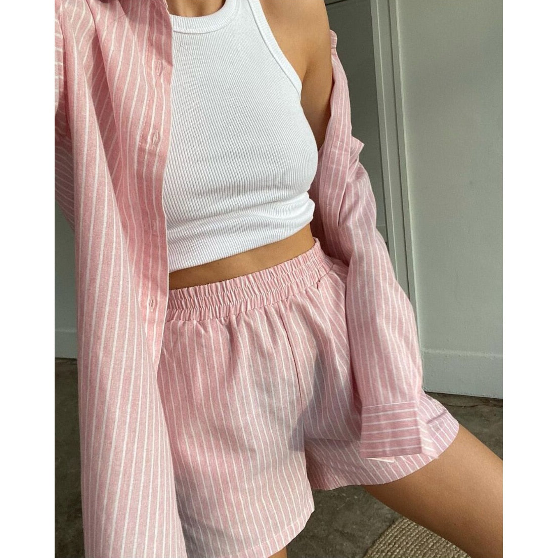 Frau in rosa gestreiftem Pyjama-Set mit weißem Tanktop, gemütliche Nachtwäsche, Baumwolle.