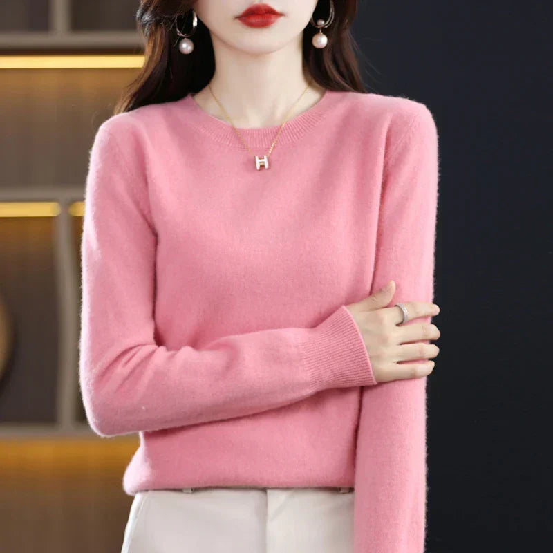 Rosa Pullover mit gerippten Bündchen, ein Arm vor dem Körper verschränkt, dazu helle Hose 10