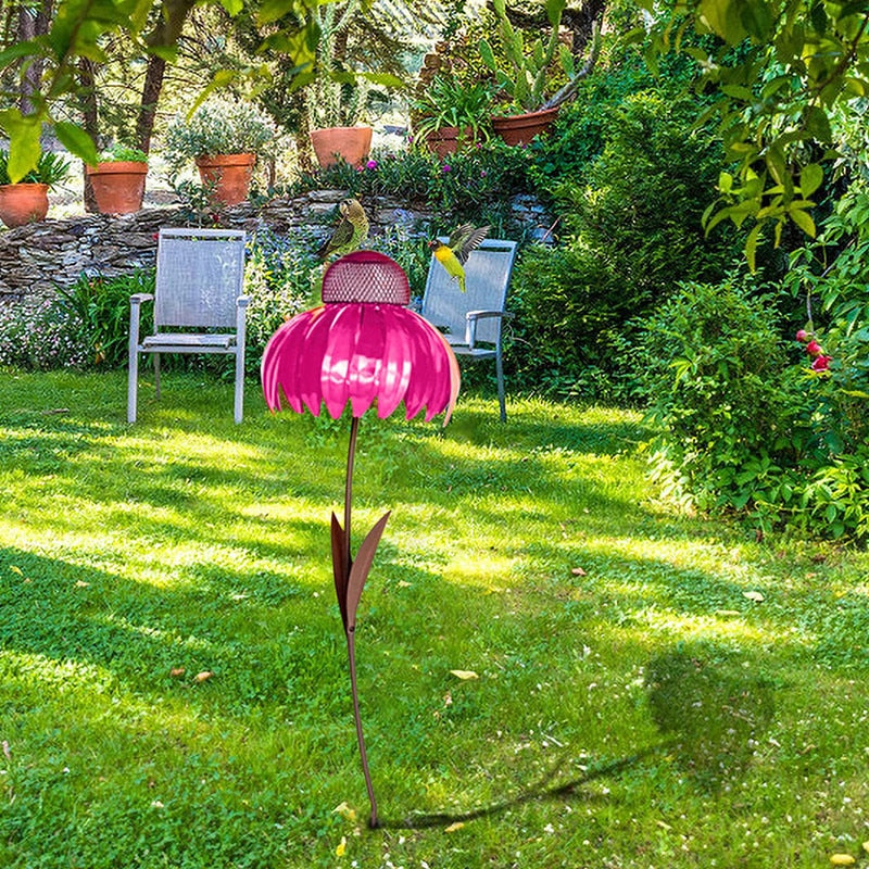 Rosa Solar-Gartenleuchte in Blumenform auf grünem Rasen, umgeben von Gartenmöbeln und Pflanzen.