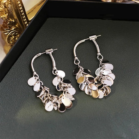 Silberne Creolen Ohrringe mit runden Anhängern, modisches Schmuckdesign, Damenaccessoire.