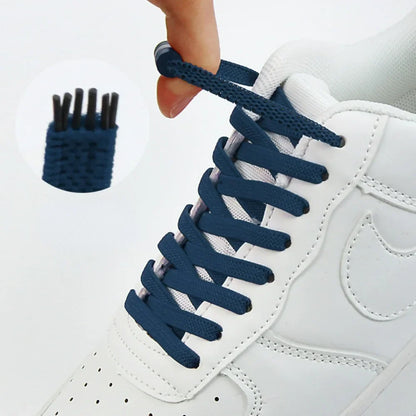 Dunkelblaue flache Schnürsenkel an weißem Sneaker, Hand hält das Ende, Vergrößerung zeigt das Gewebe 1