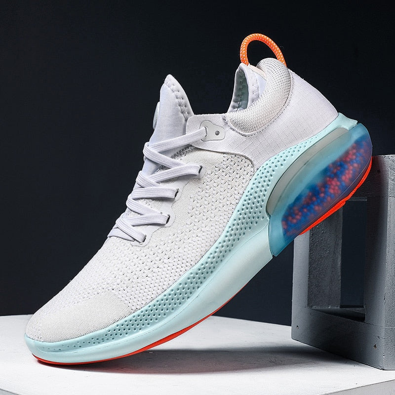 Weiße Sportschuhe mit blauer Sohle und orangen Akzenten, atmungsaktives Mesh, Herren Sneaker.
